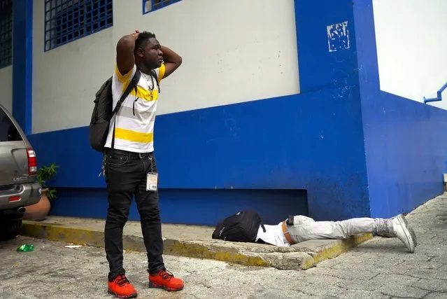 Haitian journalist Romelo Vilsaint, who was fatally wounded lies face down inside the parking lot of a police station, in Port-au-Prince, Haiti, Sunday, October 30, 2022. (Photo by Ramon Espinosa/AP Photo)