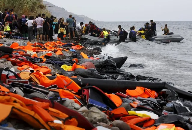 Syrian refugees arrive on the Greek island of Lesbos in an overcrowded dinghy after crossing a part of the Aegean Sea from the Turkish coast September 22, 2015. (Photo by Yannis Behrakis/Reuters)