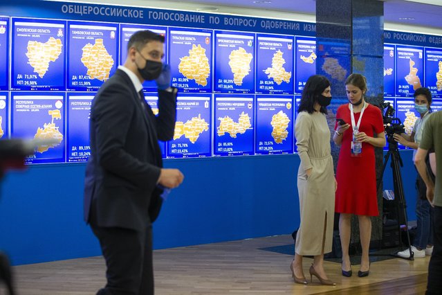 Staff members of the Russian Central Election Commission, wearing face masks and gloves to protect against coronavirus, gather prior to a news conference with Ella Pamfilova, head of Russian Central Election Commission, in front of an electronic screen showing the results of constitution vote in Moscow, Russia, Thursday, July 2, 2020. Almost 78% of voters in Russia have approved amendments to the country's constitution that will allow President Vladimir Putin to stay in power until 2036, Russian election officials said Thursday after all the votes were counted. Kremlin critics said the vote was rigged. (Photo by Alexander Zemlianichenko/AP Photo)
