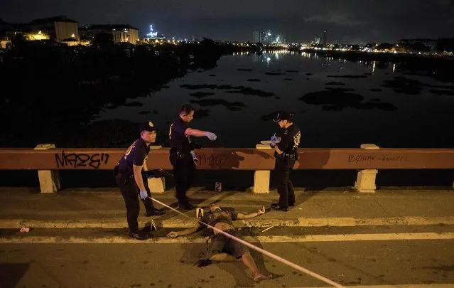 A dead body of an alleged robber lies on a bridge in Manila on December 10, 2017, after he and two other accomplices attempted to snatched the motorcycle of a policeman. The knife-wielding suspect was shot when the suspect attacked the policeman. (Photo by Noel Celis/AFP Photo)