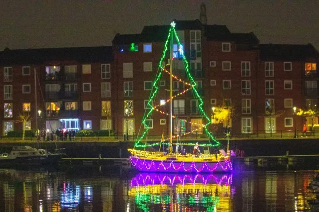 Moored yachts in Preston Marine, Lancashire, UK on December 1, 2022. A Christmas night switch on for the crowds lining the dock wall as berth holders light up their boats and enjoy an evening sail under Festive Lights. (Photo by Alamy Live News/Media Drum Images)
