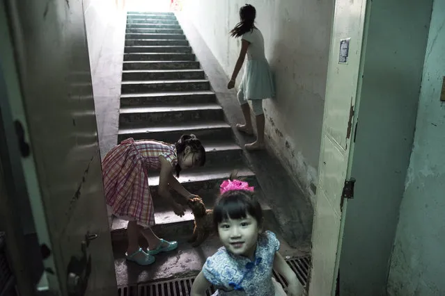 Children play on a stairway descending into a basement dwelling in Beijing on May 22, 2016. Beijing's real estate market is one of China's most expensive and that has resulted in thousands illegally living in basement “apartments”. (Photo by Michael Robinson Chavez/The Washington Post)