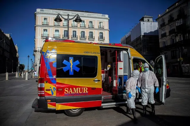 Health workers in personal protection equipments arrive at the Puerta del Sol in Madrid, Spain, Friday, August 28, 2020. Spanish authorities have announced new restrictions to prevent COVID-19. (Photo by Andrea Comas/AP Photo)