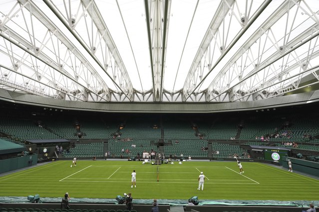 Carlos Alcaraz of Spain, right, and Novak Djokovic of Serbia, left, during a practice session on Centre Court at the All England Lawn Tennis and Croquet Club, ahead of the Wimbledon Championships in London, Thursday, June 26, 2025. (Photo by Kirsty Wigglesworth/AP Photo)