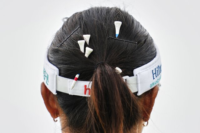 Tees are pinned in the hair of Lydia Ko of New Zealand during the third round of the Women's British Open golf championship, at Royal Porthcawl Golf Club in Porthcawl, Wales, August 2, 2025. (Photo by Kin Cheung/AP Photo)
