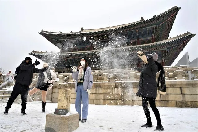 Visitors toss snow to enhance their pictures at the Gyeongbok Palace, the main royal palace during the Joseon Dynasty, and one of South Korea's well known landmarks in Seoul, South Korea, Thursday, anuary 26, 2023. (Photo by Ahn Young-joon/AP Photo)