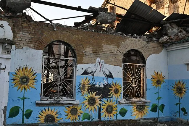 This photograph taken on December 23, 2022 shows a painting on a wall of a heavily damaged house of culture in Irpin, northwest of Kyiv, amid the Russian invasion of Ukraine. (Photo by Genya Savilov/AFP Photo)