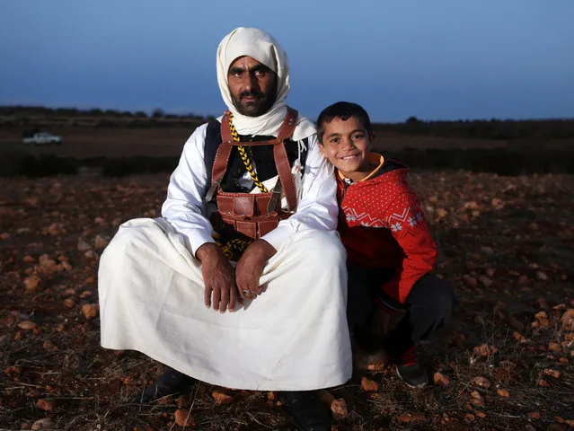 A man dressed in a traditional costume poses with his son during a wedding parade in Shahhat, Libya October 1, 2016. Picture taken October 1, 2016. (Photo by Esam Omran Al-Fetori/Reuters)