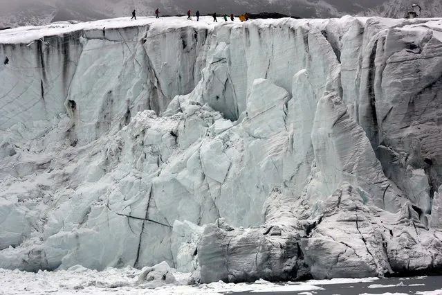 Members of the glaciology unit of the Peruvian national water authority walk on Pastoruri glacier in Huaraz, Peru, Thursday, December 4, 2014. According to Alejo Cochachin, coordinator of the glaciology unit, The Pastoruri glacier retreated 576 meters between 1980 and 2014. Peru's glaciers have lost more one-fifth of their mass in just three decades, and the 70 percent Peru's 30 million people who inhabit the country's Pacific coastal desert, depend on glacial runoff for hydropower and to irrigate crops, meaning their electricity and long-term food security could also be in peril. (Photo by Rodrigo Abd/AP Photo)