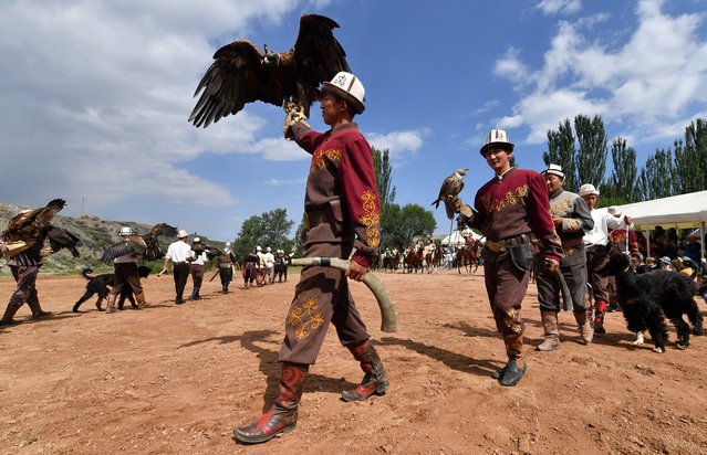 Kyrgyz berkutchi (eagle hunters) carry their golden eagles during the hunting festival “Salburun”, in the village of Bokonbayev, near Lake Issyk-Kul, on August 2, 2025. (Photo by Vyacheslav Oseledko/AFP)