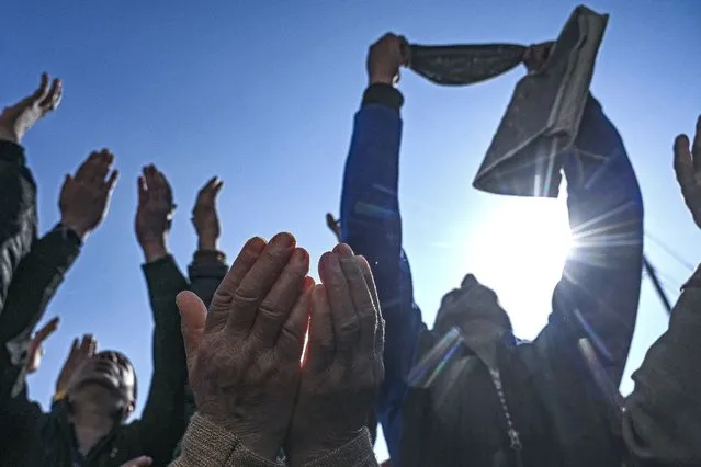 Muslims devotees react as a priest displays a holy relic, believed to be a hair from the Prophet Muhammad's beard, during the last Friday of Miraj-Ul-Alam (ascension to heaven) celebrations at Kashmir's main Hazratbal shrine in Srinagar on February 24, 2023. (Photo by Tauseef Mustafa/AFP Photo)