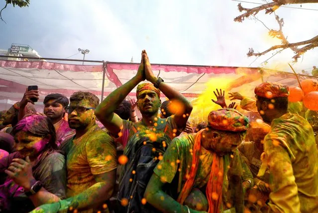 Hindu devotees are seen playing with Colorful powders and water during the Holi Festival celebration in Mathura, India on March 4, 2023. This event is popularly named as Chaddimar Holi where women beat men with small sticks as per traditional culture of Gokul. Gokul is the birth place of Hindu Lord Krishna who used to play Holi with his friends like this way as per Local belief. (Photo by Avishek Das/SOPA Images/Rex Features/Shutterstock)