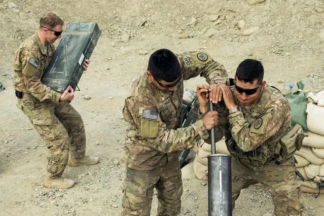 U.S. soldiers from the 3rd Cavalry Regiment clean a mortar during an exercise on forward operating base Gamberi in the Laghman province of Afghanistan December 24, 2014. (Photo by Lucas Jackson/Reuters)