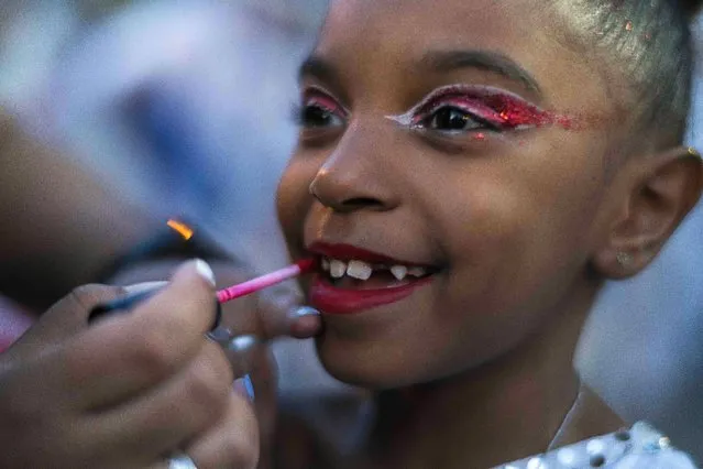 A girl has her make up done before “Las llamadas” carnival parade in Montevideo, Uruguay, Thursday, February 10, 2022. (Photo by Matilde Campodonico/AP Photo)