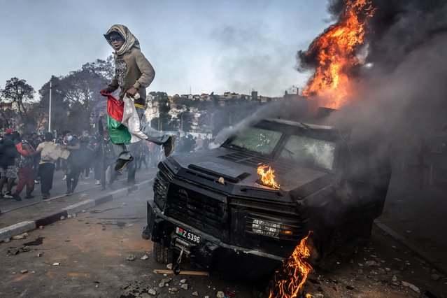 A protester holding a Malagasy flag jumps from a vandalised Gendarmerie armoured vehicle as members of a section of the Malagasy army arrive to take control of the area around Lake Anosy following clashes between demonstrators and security forces during protests calling for the resignation of President Andry Rajoelina in Antananarivo, on October 11, 2025. Groups of Madagascar soldiers joined thousands of protestors in the capital on October 11, 2025, after announcing they would refuse any orders to shoot demonstrators.
Fresh youth-led demonstrations in Antananarivo drew large crowds in one of the biggest gatherings since a protest movement erupted on the Indian Ocean island on September 25. After police used stun grenades and tear gas to try to disperse the demonstrators, soldiers arrived at the heart of the gathering near the Lake Anosy area where they were welcomed with cheers. (Photo by Luis Tato/AFP Photo)