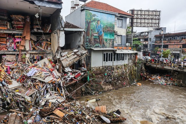 People look at collapsed buildings near a river due to major flood in Denpasar, Bali, Indonesia on 10 September 2025. Several areas in Bali have experienced severe flooding due to heavy rainfall all night long. (Photo by Johannes P. Christo/Anadolu via Getty Images)