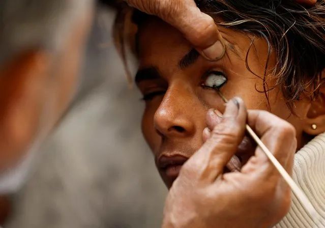 A Nepalese Muslim man has kohl applied to his eyelid at a mosque as he arrives for the mass prayer during the Muslim holy month of Ramadan in Kathmandu, Nepal on March 24, 2023. (Photo by Navesh Chitrakar/Reuters)