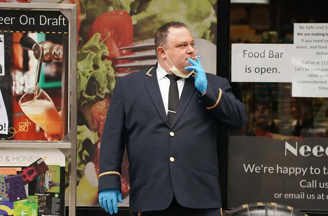 Taking a smoke break on 8th ave in midtown Manhattan on March 20, 2020. John X. works in nearby building as a doorman. He is wearing latex gloves and a mask because of coronavirus. (Photo by Robert Miller/The New York Post)