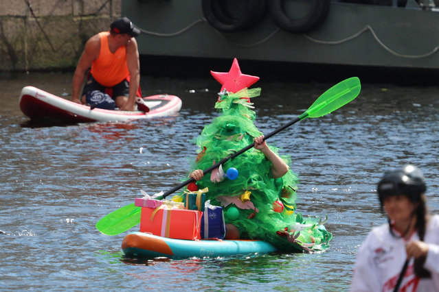 Participants make their way on the Moyka river during the Fontanka SUP stand up paddle boarding festival in Saint Petersburg, Russia on August 3, 2024. (Photo by Anton Vaganov/Reuters)