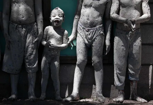 A boy covered in reef-mud reacts as he stands with other boys in the village of Ambo on South Tarawa in the central Pacific island nation of Kiribati May 25, 2013. (Photo by David Gray/Reuters)