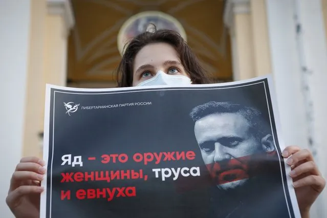 A protester stands holds a poster reads “poison is the weapon of a woman, a coward and a eunuch!” during a picket in support of Russian opposition leader Alexei Navalny in the center of St. Petersburg, Russia, Thursday, August 20, 2020. Russian opposition politician Alexei Navalny is on a hospital ventilator in a coma, after falling ill from a suspected poisoning, according to his spokeswoman Kira Yarmysh. (Photo by Elena Ignatyeva/AP Photo)