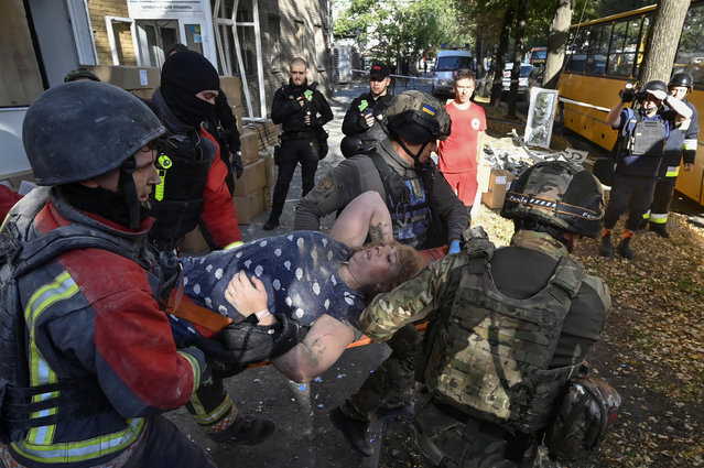Rescuers and police officers carry Yuliia, 35, after she was rescued from the debris of her apartment building hit by a Russian air strike, amid Russia's attack on Ukraine, in Zaporizhzhia, Ukraine on September 29, 2024. (Photo by Reuters/Stringer)