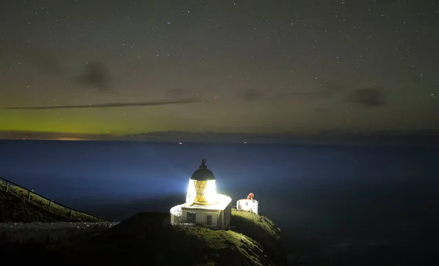 St. Abbs Lighthouse, as the Northern Lights appear on the horizon in Eyemouth, Scotland on November 2, 2016. (Photo by Owen Humphreys/PA Wire)