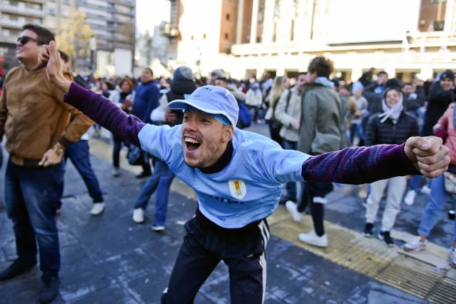 In this June 15, 2018 photo, a fan of Uruguay's national soccer team reacts after Jose Gimenez scores the winning goal during a televised broadcast of the Russia 2018 World Cup match between Egypt and Uruguay, in downtown Montevideo, Uruguay. (Photo by Matilde Campodonico/AP Photo)