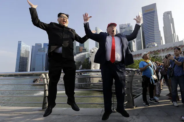 Kim Jong Un and Donald Trump impersonators, Howard X, left, and Dennis Alan, second left, pose for photographs during their visit to the Merlion Park, a popular tourist destination in Singapore, on Friday, June 8, 2018. Kim Jong Un lookalike who uses the name Howard X said he was detained and questioned upon his arrival in Singapore on Friday, days before a summit between the North Korean leader and President Donald Trump. (Photo by Wong Maye-E/AP Photo)