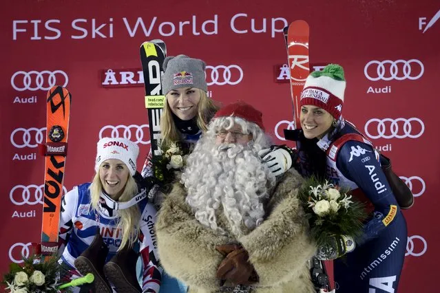 (L-R) Eva-Maria Brem of Austria, Lindsey Vonn of the U.S. and Federica Brignone of Italy pose on the podium with a man dressed as Father Christmas after the women’s World Cup giant slalom in Are, Sweden, December 12, 2015. (Photo by Pontus Lundahl/Reuters/TT News Agency)
