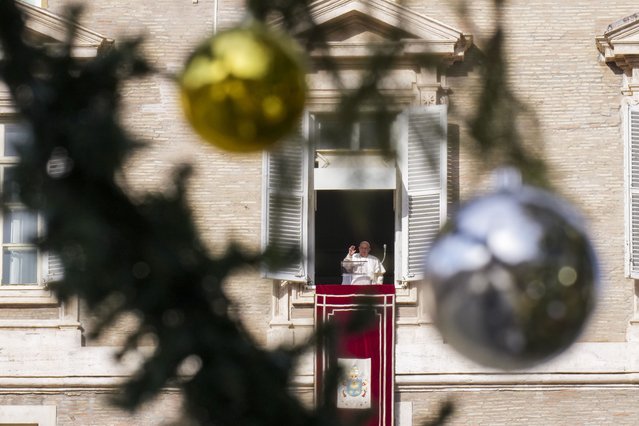 Pope Francis is seen through a 29-meter-tall Christmas tree as he appears at his studio's window in St. Peter's Square at The Vatican, Sunday, December 8, 2024, to bless the faithful and pilgrims gathered for the noon Angelus prayer. (Photo by Andrew Medichini/AP Photo)