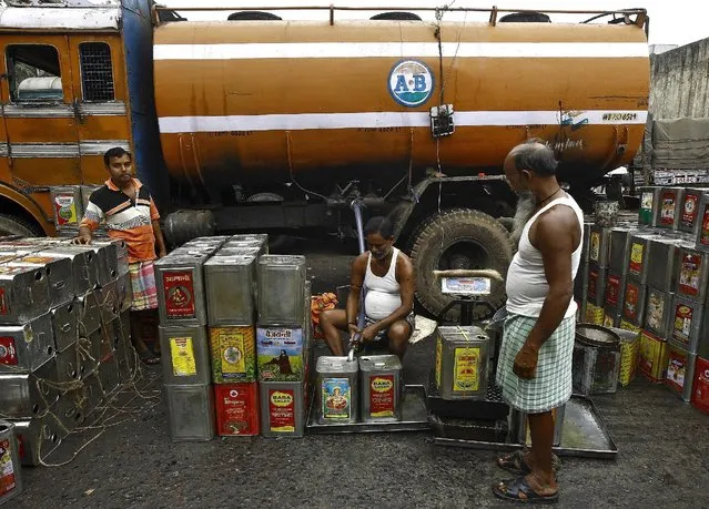 Workers fill cooking oil in tins from a tanker at a wholesale market in Kolkata, India, December 14, 2015. (Photo by Rupak De Chowdhuri/Reuters)