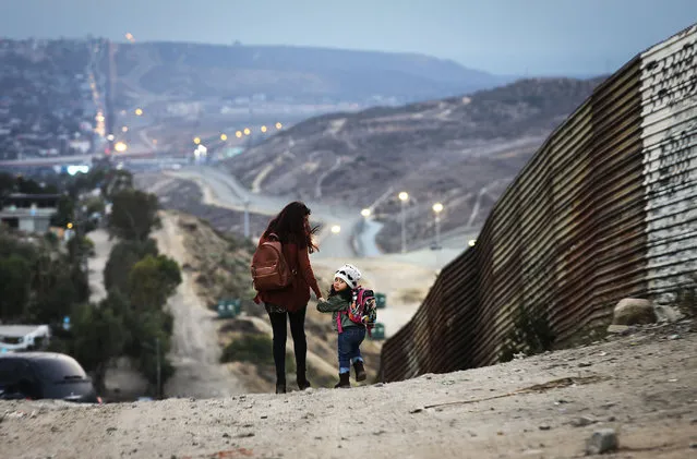 Local residents walk along the Mexico side of the U.S.-Mexico border on June 19, 2018 in Tijuana, Mexico. U.S. President Trump's Mexican border policy has raised worldwide controversy in recent days as Republicans attempt to pass an immigration reform bill. (Photo by Mario Tama/Getty Images)