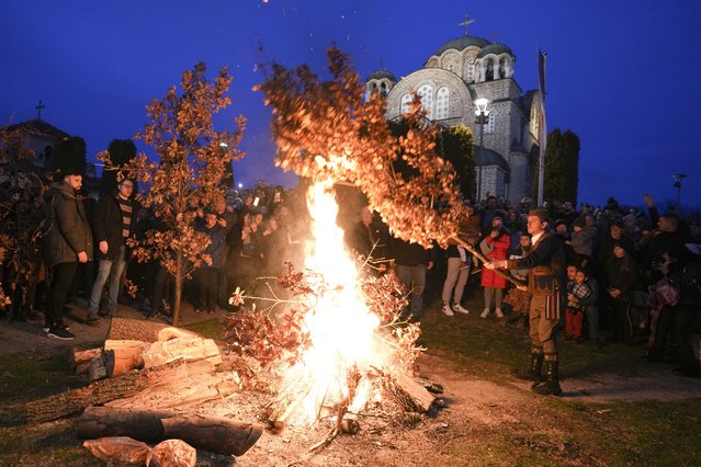 Christian Orthodox believers, who follow the Julian calendar and celebrate Christmas on Jan. 7, burn dried oak branches, the Yule log symbol for the Orthodox Christmas Eve, in front of St. Luke church in Belgrade, Serbia, Monday, January 6, 2025. (Photo by Darko Vojinovic/AP Photo)