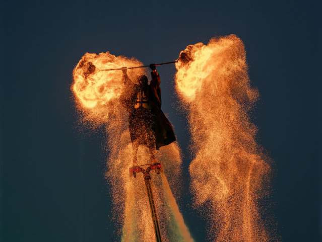 A folk artist on a flyboard shakes iron nets with hot charcoals to create sparks during Huohu (fire pot) performance at Yuncheng salt lake scenic area on January 31, 2025 in Yuncheng, Shanxi Province of China. A festive atmosphere has permeated across China as various celebrations are taking place across the country to mark the Chinese New Year or Spring Festival. (Photo by Yan Xin/VCG via Getty Images)