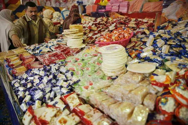 A vendor waits for customers to buy handmade sweets at a street market ahead of Mawlid al-Nabi, the birthday of Prophet Mohammad, in Old Cairo, Egypt, December 21, 2015. (Photo by Amr Abdallah Dalsh/Reuters)