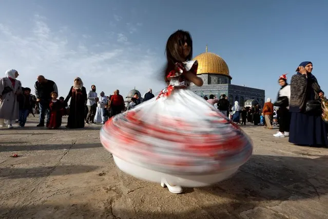 A girl dances during celebrations after Palestinians performed Eid al-Fitr prayers which marks the end of the holy fasting month of Ramadan, on the compound known to Muslims as Noble Sanctuary and to Jews as Temple Mount in Jerusalem's Old City on May 2, 2022. (Photo by Ammar Awad/Reuters)