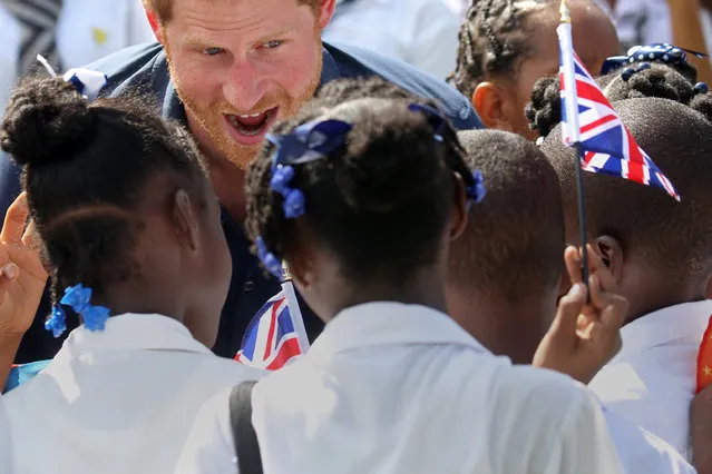 Britain's Prince Harry talks with school children as he tours a sports facility during an official visit of St. George's, Grenada November 28, 2016. (Photo by Carlo Allegri/Reuters)
