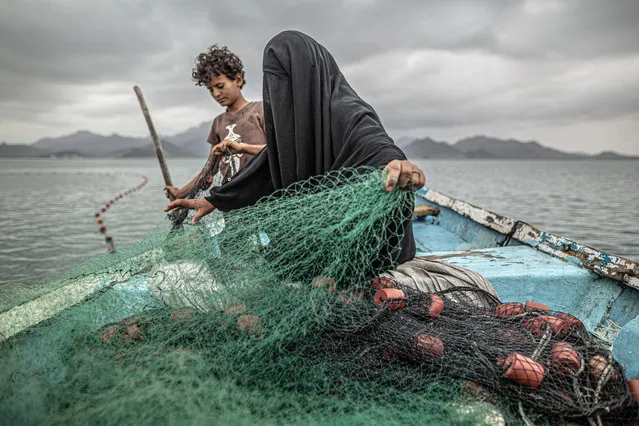 Contemporary issues – first prize, singles. Yemen: Hunger, Another War Wound. Fatima and her son prepare a fishing net in Khor Omeira Bay, Yemen, on 12 February 2020. Fatima has nine children. To provide for them, she makes a living from fishing. Although her village was devastated by armed conflict in Yemen, Fatima returned to resume her livelihood, buying a boat with money she earned selling fish. The conflict – between Houthi Shia Muslim rebels and a Sunni Arab coalition led by Saudi Arabia – dates from 2014, and has led to what Unicef has termed the world’s largest humanitarian crisis. (Photo by Pablo Tosco/World Press Photo 2021)