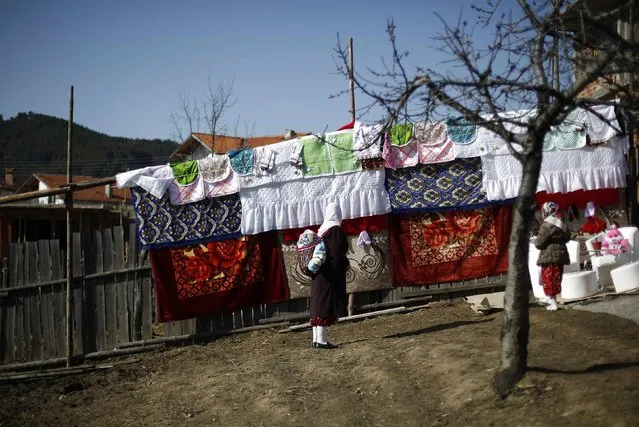 A Bulgarian Muslim woman looks at the dowry during the wedding ceremony of Bulgarian Muslims Fikrie Bindzheva and Azim Liumankov in the village of Ribnovo, in the Rhodope Mountains, February 15, 2015. (Photo by Stoyan Nenov/Reuters)