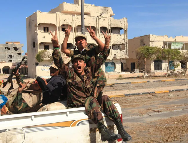 Anti-Gaddafi fighters gesture as they celebrate the fall of Muammar Gaddafi in Sirte, Libya, October 20, 2011. (Photo by Esam Al-Fetori/Reuters)