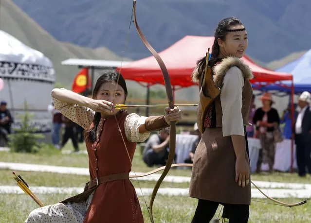 Kyrgyz girls show their archery skills during the Kyrgyz Culture Festival  in Naryn, some 310 kilometers from the country's capital Bishkek, Kyrgyzstan, 26 June 2022. The Kyrgyz city of Naryn hosted the festival during which they opened an ethno-complex with samples of traditional crafts and goods for foreign tourists. (Photo by Igor Kovalenko/EPA/EFE)