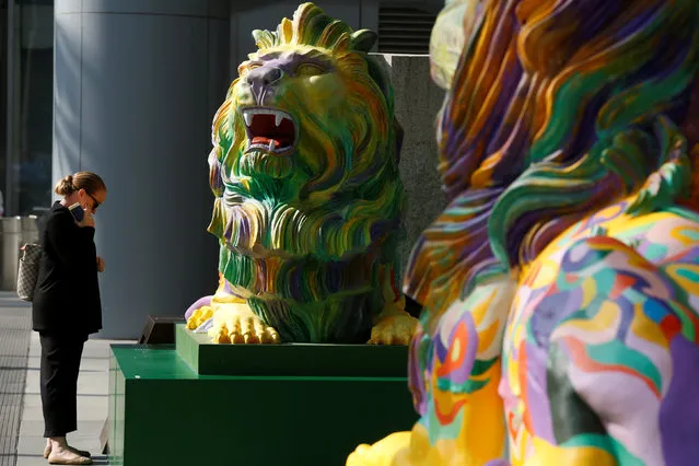 A passerby reads an introduction on “Stephen”, one of the two lions in rainbow colors to show support for the LGBT (lesbian, gay, bisexual and transgender) community, being newly displayed at HSBC's main branch in Hong Kong, China December 7, 2016. (Photo by Bobby Yip/Reuters)