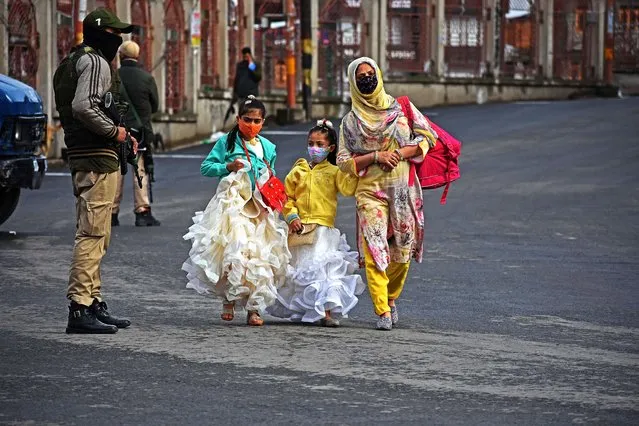 Girls walk along with their mother on Eid-al-Fitr day in Srinagar, Kashmir on May 13, 2021. The Jammu and Kashmir authorities tightened COVID-19 curfew on Eid day to stop further spread of COVID-19 Coronavirus pandemic. (Photo by Faisal Khan/Anadolu Agency via Getty Images)