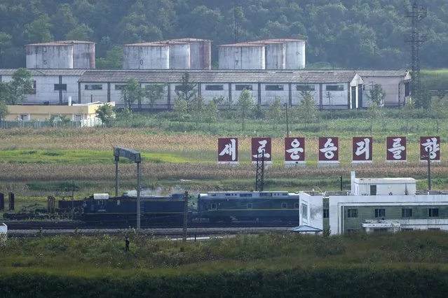 A green train with yellow trimmings, resembling one used by North Korean leader Kim Jong Un on his previous travels, is seen steaming by a slogan which reads “Towards a new victory” on the North Korea border with Russia and China seen from China's Yiyanwang Three Kingdoms viewing platform in Fangchuan in northeastern China's Jilin province on Monday, Sept. 11, 2023. Russia and North Korea confirmed Monday that North Korean leader Kim Jong Un will visit Russia in a highly anticipated meeting with President Vladimir Putin that has sparked Western concerns about a potential arms deal for Moscow's war in Ukraine. (Photo by Ng Han Guan/AP Photo)