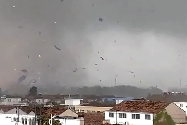 In this frame taken from a video, debris scatters in the sky after a tornado swept through houses in Suqian city in eastern China's Jiangsu Province on Tuesday, September 19, 2023. Two tornadoes within hours killed and injured several people in eastern China, state media said Wednesday. (Photo by Zhang via AP Photo)