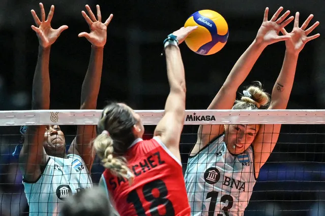 Peru's Ysabella Sanchez (C) spikes the ball as Argentina's Bianca Farriol (R) and Erika Mercado (L) defend during the match on the final day of the Volleyball World Cup 2023 women's Olympic qualifying tournament between Peru and Argentina at Yoyogi National Stadium in Tokyo on September 24, 2023. (Photo by Richard A. Brooks/AFP Photo)