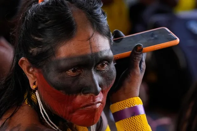 A Kayapo Indigenous woman listens to a message on her cell phone, during the Supreme Court´s vote to decide on whether to overturn or maintain a ruling on the legality of boundaries for vast Indigenous lands, and whether Indigenous people can claim their right to be on some protected areas, in Brasilia, Brazil, Wednesday, September 20, 2023. (Photo by Eraldo Peres/AP Photo)