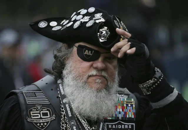An Oakland Raiders supporter poses for a photo on Wembley Way before an NFL football game against Seattle Seahawks at Wembley stadium in London, Sunday, October 14, 2018. (Photo by Tim Ireland/AP Photo)