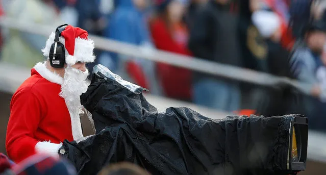 A camera operator dressed as Santa Claus as the New England Patriots play the New York Jets in the third quarter of their NFL game at Gillette Stadium in Foxborough, Massachusetts, USA, 24 December 2016. (Photo by C.J. Gunther/EPA)